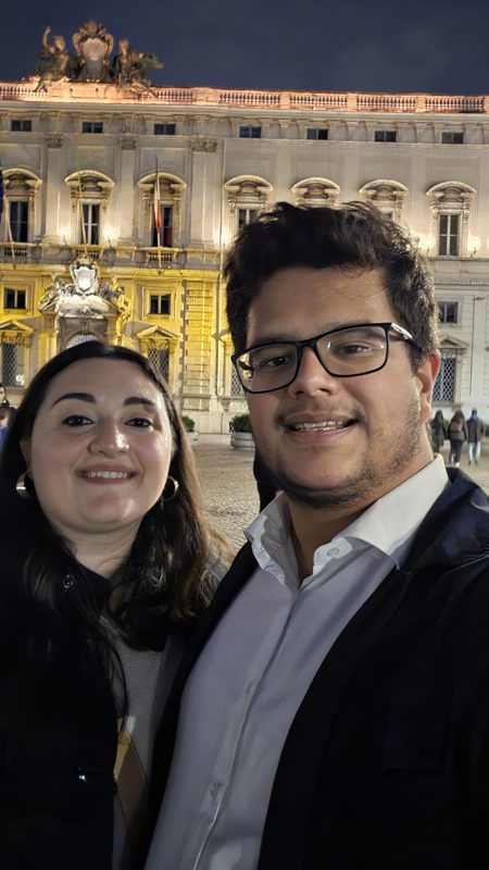 Pedro e Marialuisa di sera, davanti a un palazzo illuminato